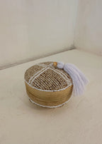 Dit opbergdoosje volledig bedekt met beige en witte glaskralen en afgewerkt met een zachte witte kwast. Perfect om sieraden in op te bergen.