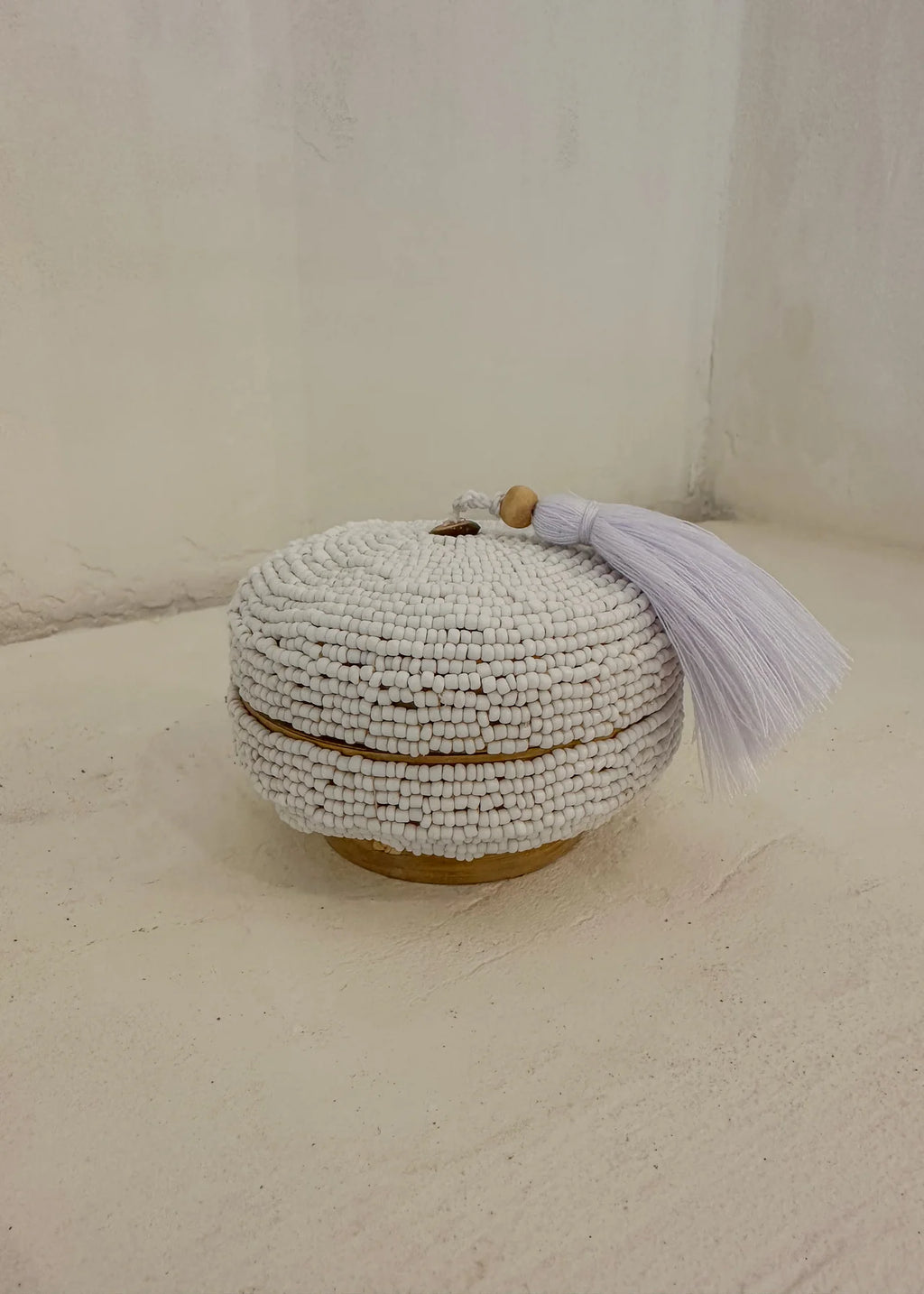 Dit opbergdoosje volledig bedekt met witte glaskralen en afgewerkt met een zachte witte kwast. Perfect om sieraden in op te bergen.