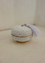 Dit opbergdoosje volledig bedekt met witte glaskralen en afgewerkt met een zachte witte kwast. Perfect om sieraden in op te bergen.